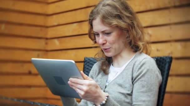 Jeune femme bénéficie d'une tablette dans un café bar — Video