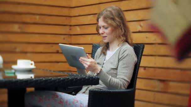 Jeune femme bénéficie d'une tablette dans un café bar — Video