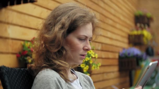 Jonge vrouw geniet van een tablet in een café-bar — Stockvideo