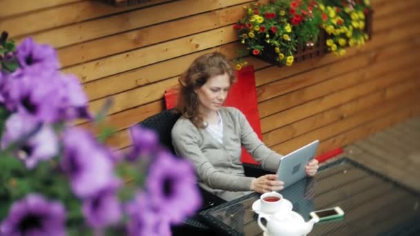 Ung kvinna har en surfplatta i en cafébar — Stockvideo