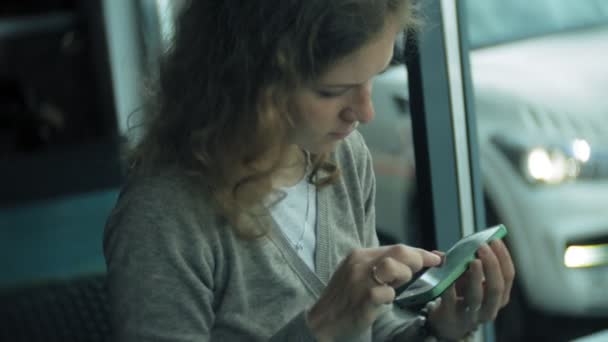 Young woman uses a tablet and phone, drinks tea in a cafe bar — Stock Video