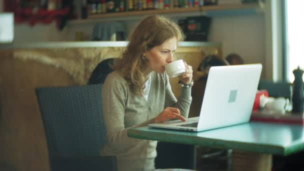 Молодая красивая деловая женщина сидит на диване за столом с планшетом и смотрит через бумагу — стоковое видео