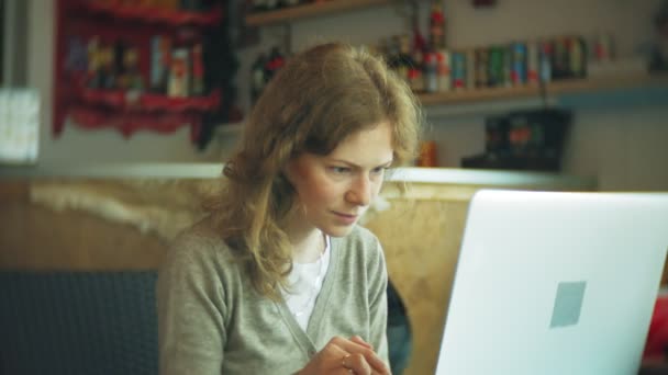 Jonge mooie zakenvrouw zittend op de Bank aan tafel met tablet en op zoek via papier — Stockvideo