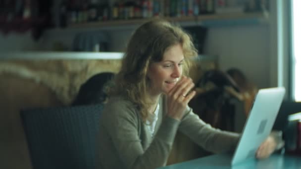 Молодая женщина наслаждается планшетом в кафе-баре — стоковое видео