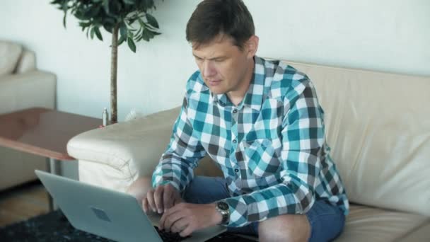 Zakenman zittend op de Bank aan tafel met de Tablet PC- en kijken via papier — Stockvideo