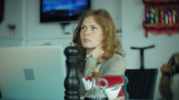 Young beautiful business woman sitting on sofa at table with tablet and looking through paper — Stock Video