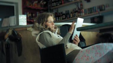 Genç kadın bir tablet bir kafe barda sahiptir