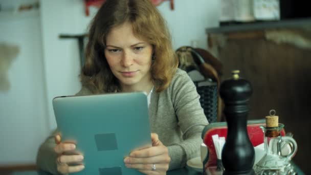 Genç kadın bir tablet bir kafe barda sahiptir — Stok video
