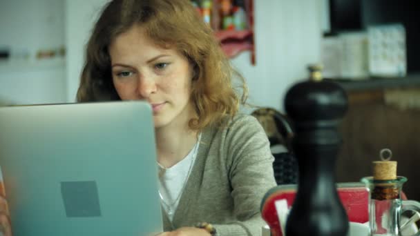 Jonge vrouw geniet van een tablet in een café-bar — Stockvideo