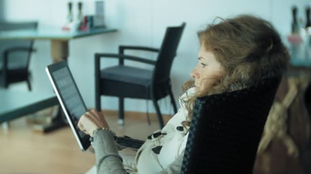 Junge Frau genießt eine Tablette in einer Café-Bar — Stockvideo