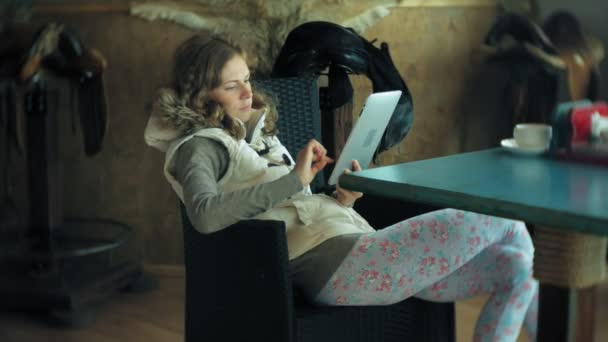 Jonge vrouw geniet van een tablet in een café-bar — Stockvideo