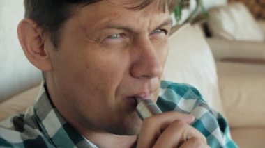 Vaping kapalı kamusal alanda genç adam. Kafede elektronik sigara içiyorum. Sigara, eski alışkanlık çıkmak için bir yol. Vaping aroma, e-sigara yerlerde sigara kullanan kentsel adam izin verilmiyor