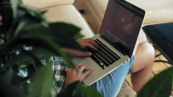 Business man sitting on sofa at table with tablet and looking through paper — Stock Video