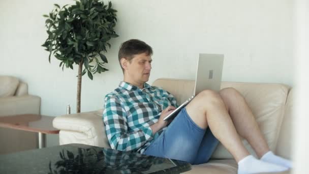 Geschäftsmann sitzt mit Tablet auf Sofa am Tisch — Stockvideo