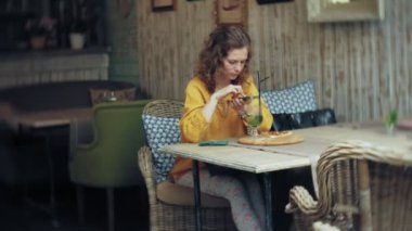 Genç kadın bir kafe barda bir smartphone cep telefonu ile bir pasta lazım