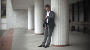 bir ofis binası için gönderilen bir genç, saygın bir iş adamı. Onun elinde tutan bir evrak çantası, belgeler üzerinden görünüyor.