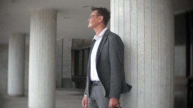 bir ofis binası için gönderilen bir genç, saygın bir iş adamı. Onun elinde tutan bir evrak çantası, belgeler üzerinden görünüyor.