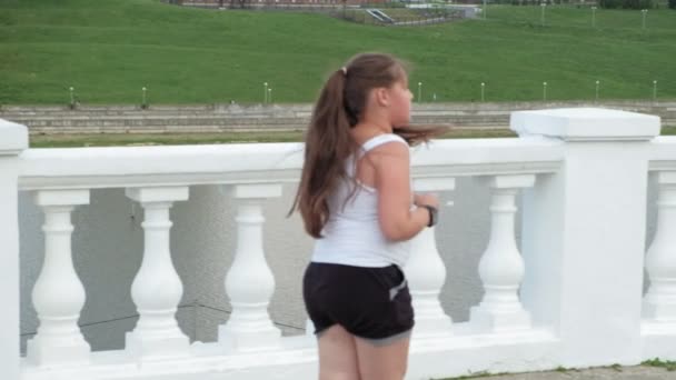Junges dickes Mädchen rennt, nimmt ab, hört Musik über Kopfhörer Konzept eines gesunden Lebensstils — Stockvideo