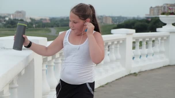 年轻的肥胖女孩奔跑, 脱落重量, 听音乐在耳机健康生活方式概念 — 图库视频影像