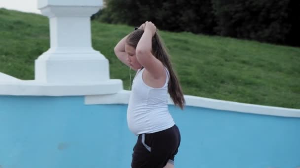 Giovane ragazza grassa correre giù per le scale, perdere peso, ascoltare musica in cuffie concetto di stile di vita sano super slow motion — Video Stock