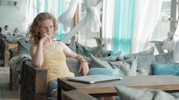 Young business woman sitting at table and taking notes in notebook.On table is laptop, smartphone. Student learning online. Blogger. — Stock Video