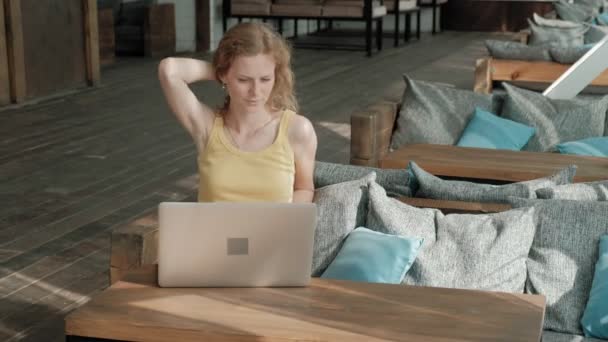 Jonge zakenvrouw zittend aan tafel en het maken van aantekeningen in notitieblok. Is de laptop, smartphone op tafel. Online leren van de leerlingen. Blogger. — Stockvideo