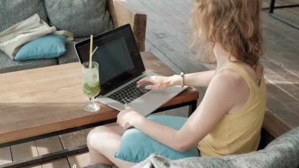 Joven mujer de negocios bebiendo cóctel mojito sentada en la mesa y tomando notas en el cuaderno. Enseñando a los estudiantes en línea. Blogger . — Vídeos de Stock