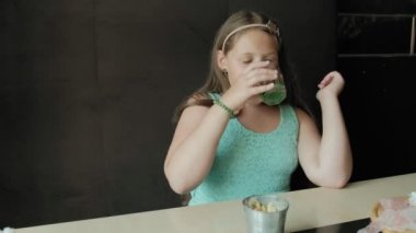 küçük kız limonata bardaktan içiyor