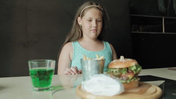 Dicke Mädchen essen eifrig einen Hamburger, Konzept einer gesunden Ernährung — Stockvideo