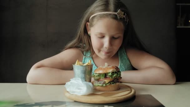 Chica gorda comiendo ansiosamente una hamburguesa, concepto de una dieta saludable — Vídeos de Stock