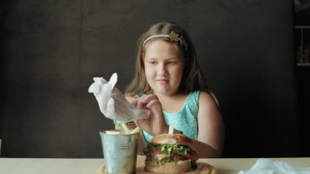 Chica gorda comiendo ansiosamente una hamburguesa, concepto de una dieta saludable — Vídeo de stock