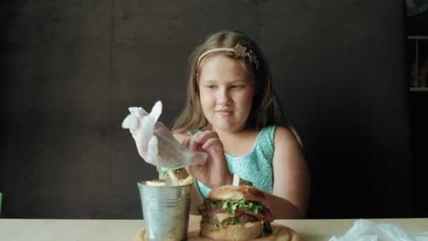 Chica gorda comiendo ansiosamente una hamburguesa, concepto de una dieta saludable — Vídeos de Stock