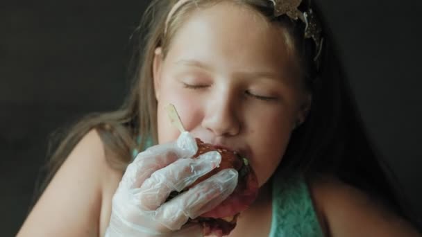 Menina gorda ansiosamente comer um hambúrguer, conceito de uma dieta saudável — Vídeo de Stock