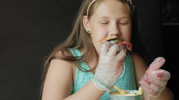 Chica gorda comiendo ansiosamente una hamburguesa, concepto de una dieta saludable — Vídeo de stock