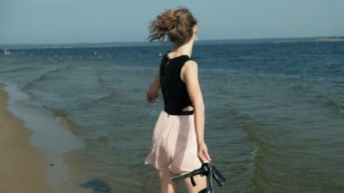 Sahilde denize sıfır, pembe şarap keyfini bir güzel elbiseli Genç Sarışın kadın süper ağır çekim