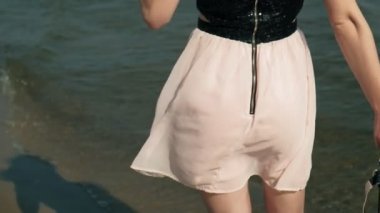 Sahilde denize sıfır, pembe şarap keyfini bir güzel elbiseli Genç Sarışın kadın süper ağır çekim