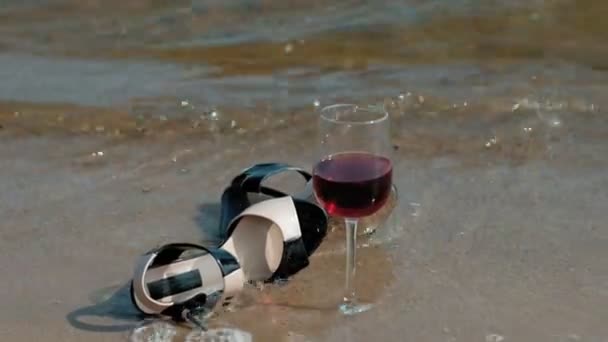 Scarpe si trovano sulla riva del mare, un bicchiere di vino si trova accanto — Video Stock