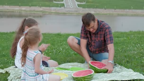 Szczęśliwa rodzina na pikniku jedzenie arbuza. — Wideo stockowe
