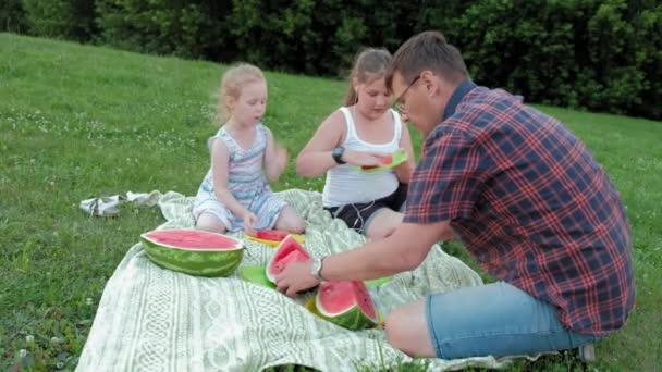 Lycklig familj på en picknick som äter vattenmelon. — Stockvideo