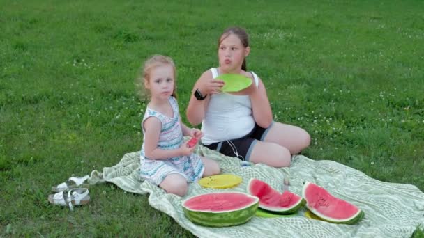 Счастливая семья на пикнике ест арбуз . — стоковое видео