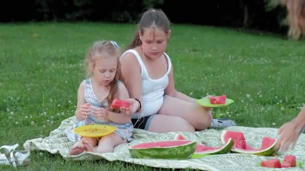Gelukkige familie op een picknick eten van watermeloen. — Stockvideo