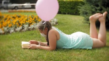 Sevimli kız parkta bir kitap okuma solunum