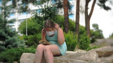 Sevimli kız parkta bir kitap okuma solunum