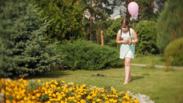 Gadis manis di respirator membaca buku di taman — Stok Video