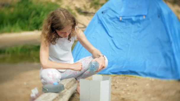 Kvinnor matlagning i plommonstop i camping med tält i bakgrunden. — Stockvideo