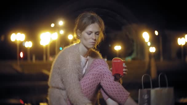 Mujer joven comiendo papas fritas en la noche al aire libre a la luz de las linternas — Vídeos de Stock