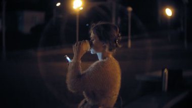 Şehir merkezinde ise cep telefonuna gece genç kadın mesaj. Mutlu kadın manifatura ile şehir içinde smartphone.