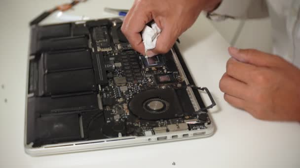 Um homem está a reparar um portátil. O conceito de reparação de computadores. Fechar-se de homem reparar placa-mãe laptop com uma chave de fenda. Manutenção do hardware da placa-mãe. Suporte de disco, reparação de computadores — Vídeo de Stock