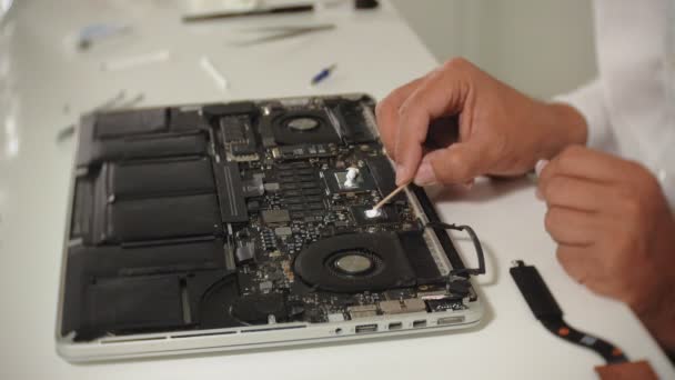 Seorang pria sedang memperbaiki laptop. Konsep perbaikan komputer. Menutup motherboard laptop manusia perbaikan dengan obeng. Pemeliharaan perangkat keras dari motherboard. Pemegang cakram, perbaikan komputer — Stok Video