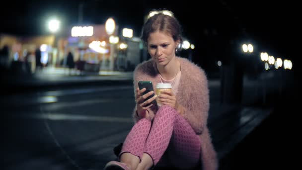 Jeune femme messagerie texte sur téléphone portable pendant la nuit au centre-ville. Joyeux textos féminins avec smartphone dans la ville . — Video